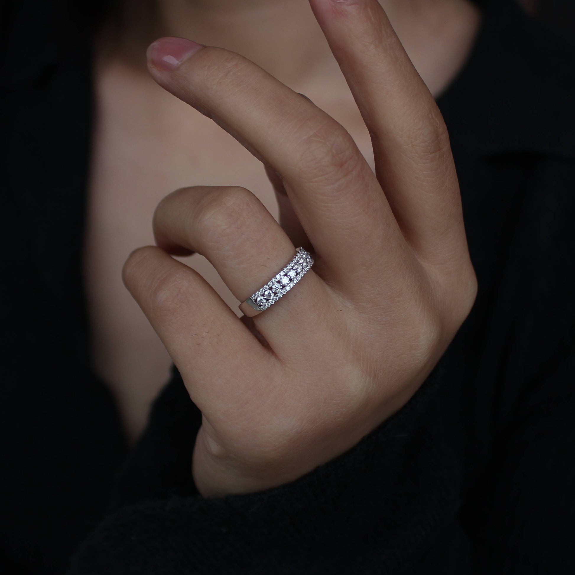 Close detail of triple pavé moissanite band worn in indoor lighting